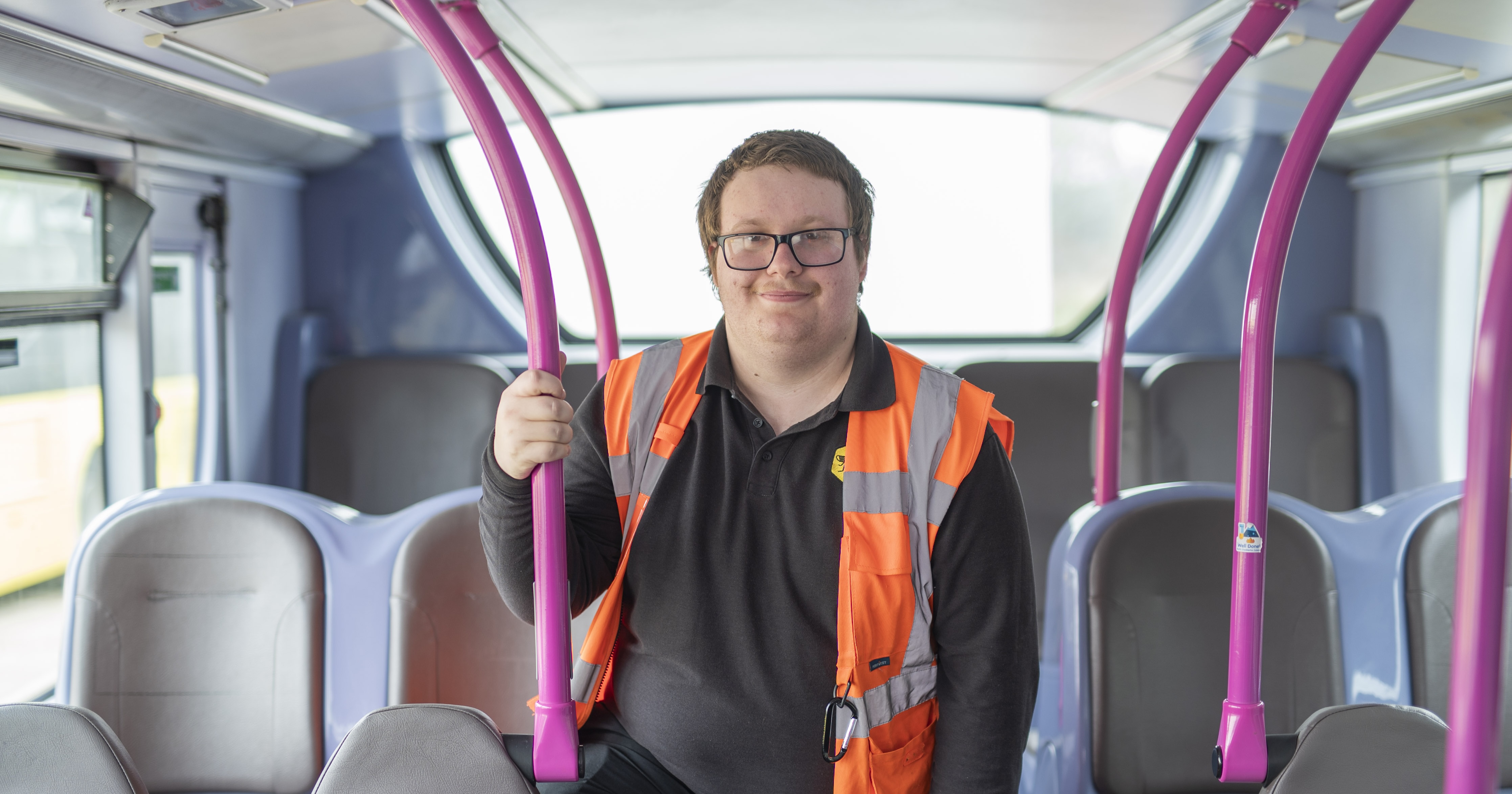 Person standing in bus whilst holding the hand support tail