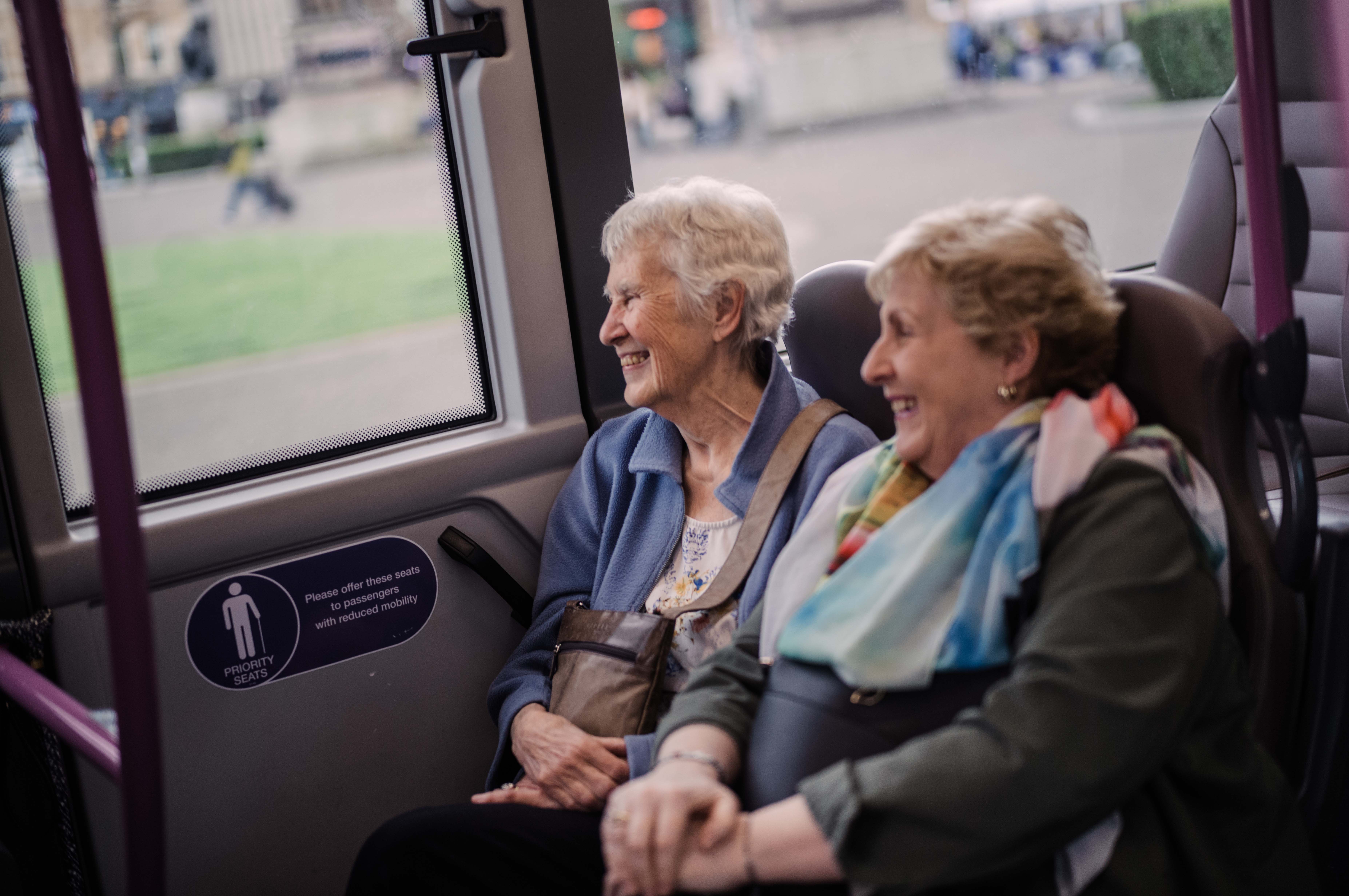 2 women sitting on the bus together