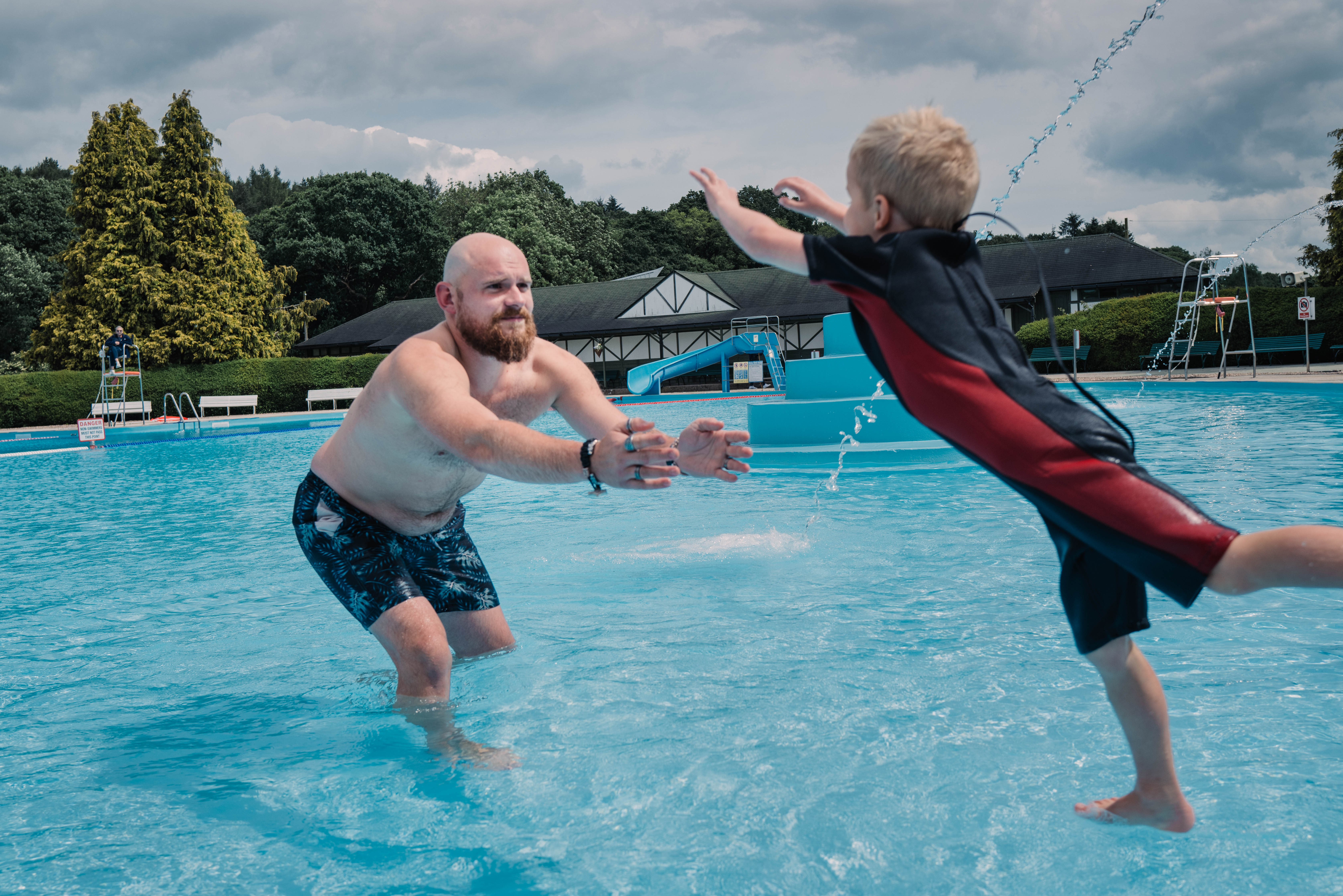 Father and child playing in a pool together