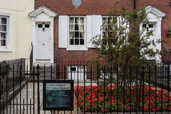 Front on view of the Charles Dickens Birthplace Museum from the street with a sign highlighting the entrance of the museum