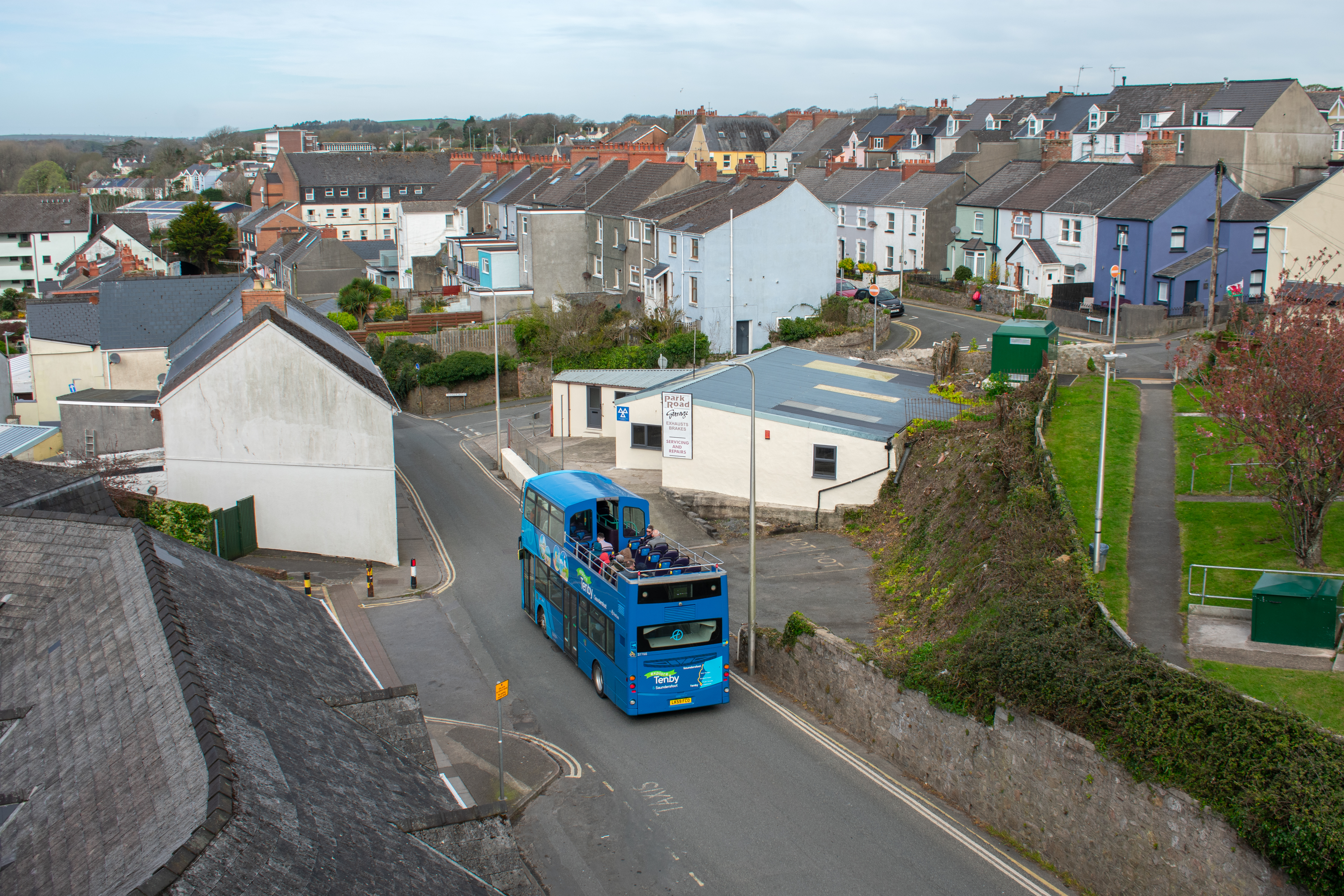 the open-top bus driving down the road in Tenby